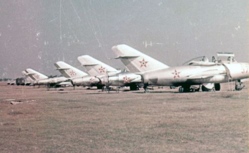 Hungarian MiG-15UTI, MiG-15bis, Yak-18 and Yak-11 trainer aircrafts on the grass airport. The MiG-15 type was used to train young pilots returning from the Soviet Union.